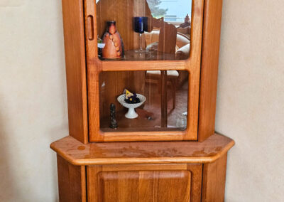Klassische Massivholz-Eckvitrine im rustikalen Stil mit verspiegelter Rückwand, Glasfenstern und unterem Stauraumschrank.